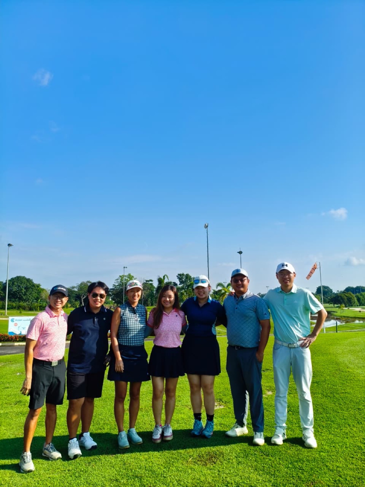 The crew lined up on the tee under a blue sky