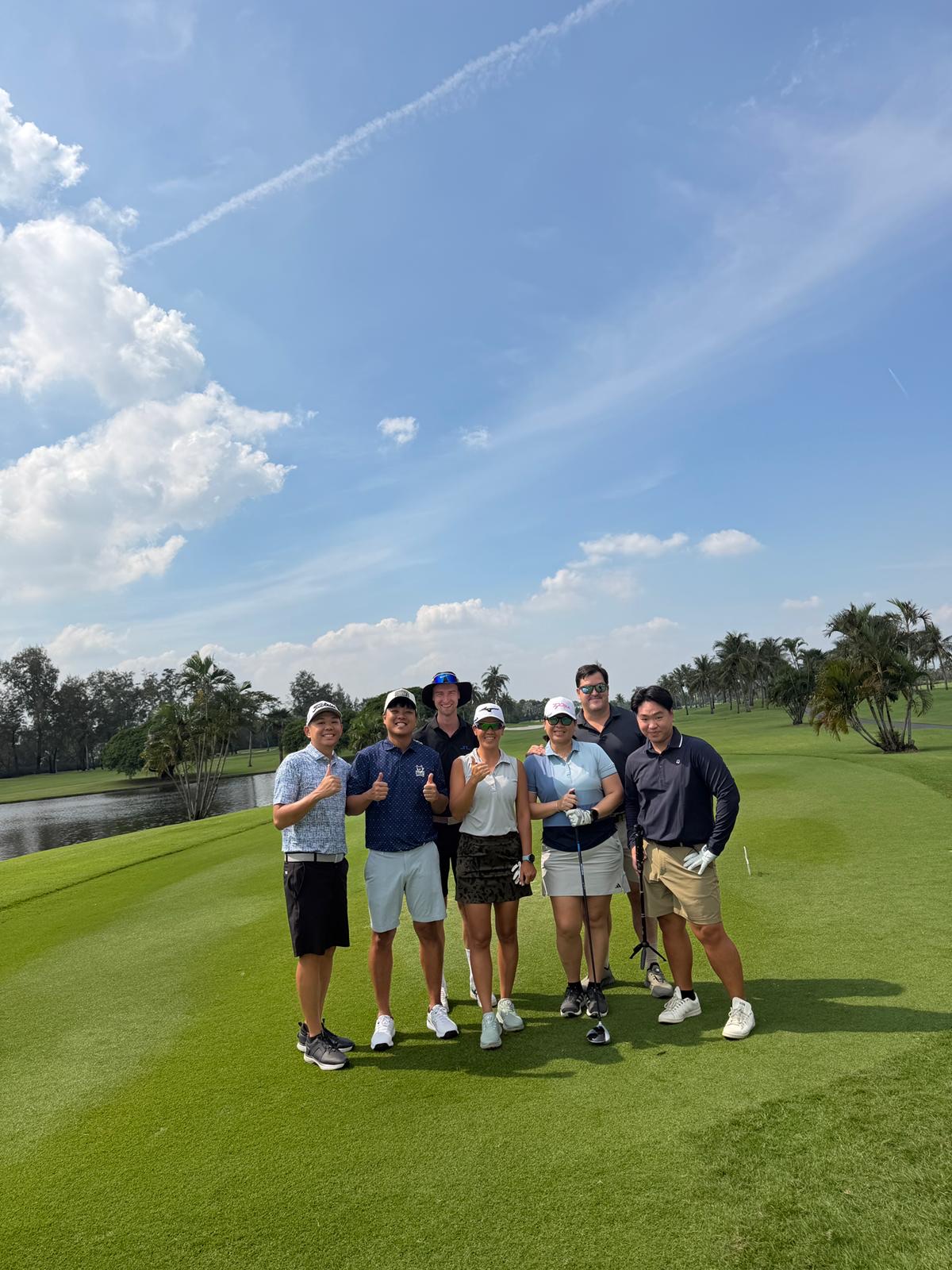 The crew giving thumbs up by the water after a round